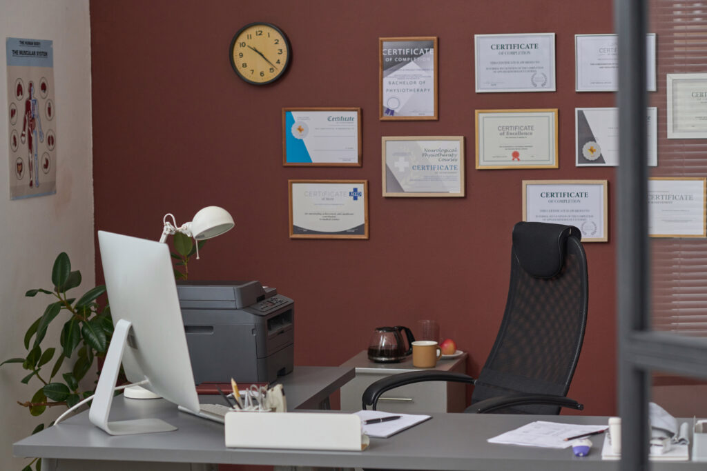Framed licenses and certificates on an office wall. Confirm a rehab’s state license and accreditation before you choose